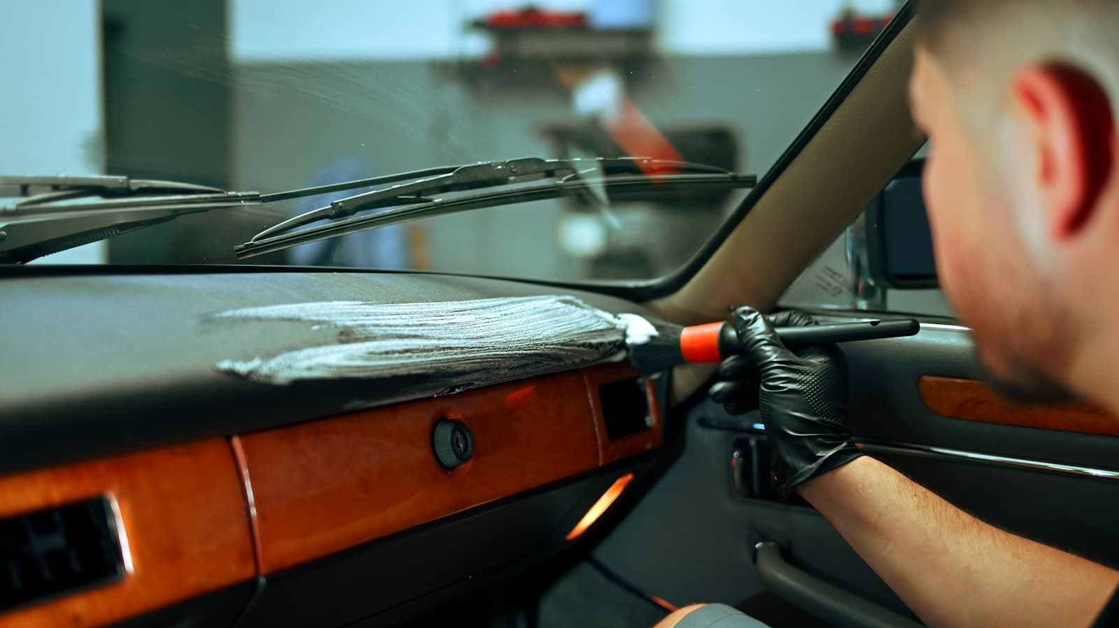 Detailing brush working cleaner into a car dashboard